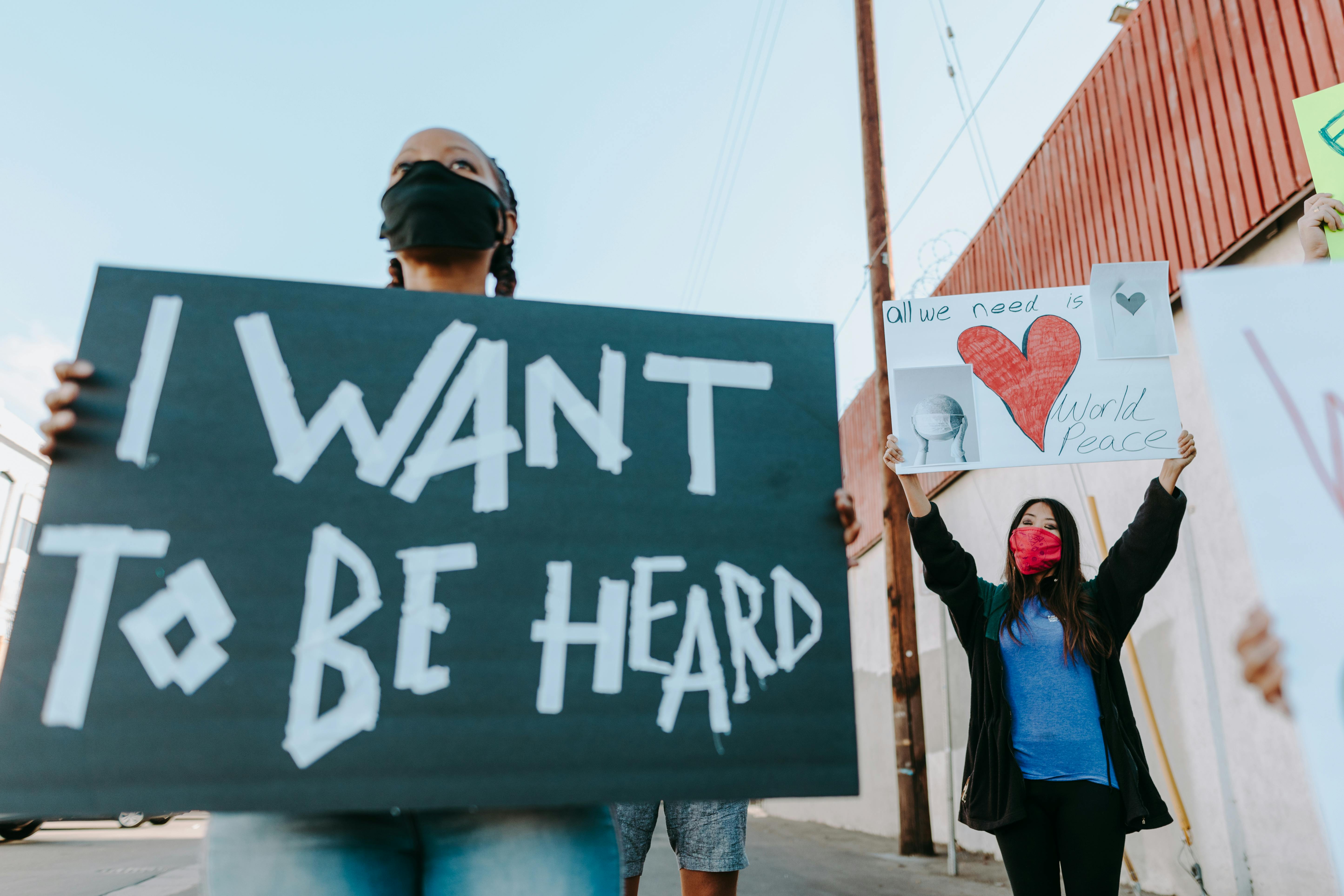 women holding placards while protesting on the street