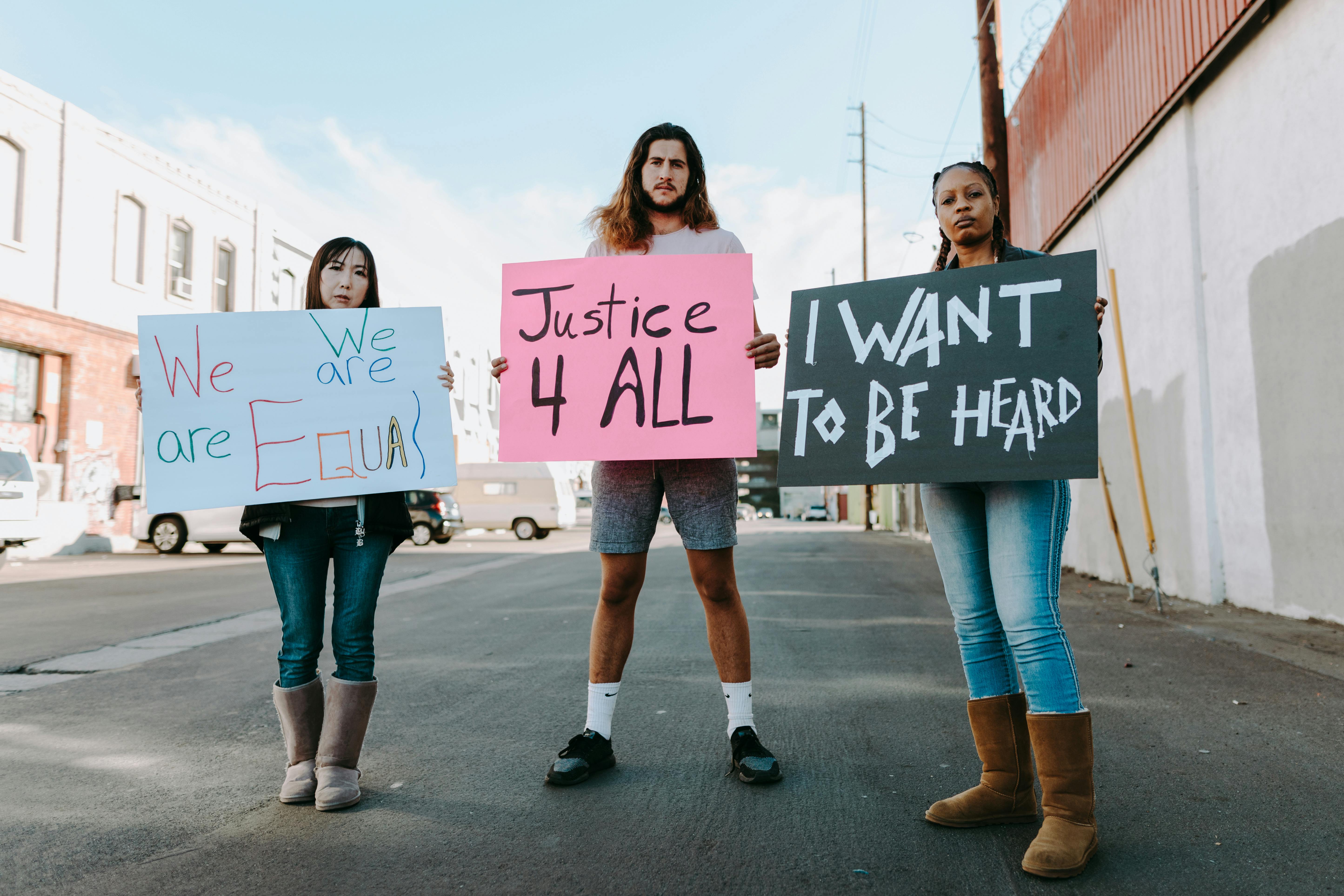 people holding placards while standing on the street