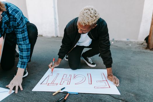 Man in Black Long Sleeve Shirt and Blue Denim Jeans Sitting on White and Black Board