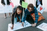 Man and Woman Writing on White Paper