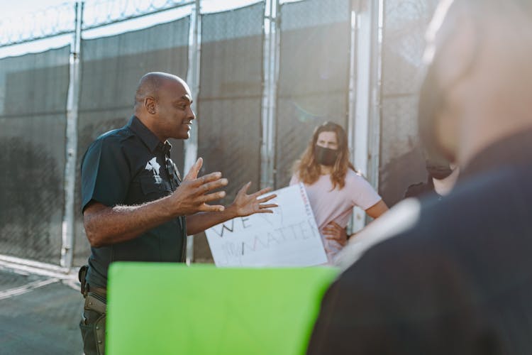 A Police Man Talking The Protesters