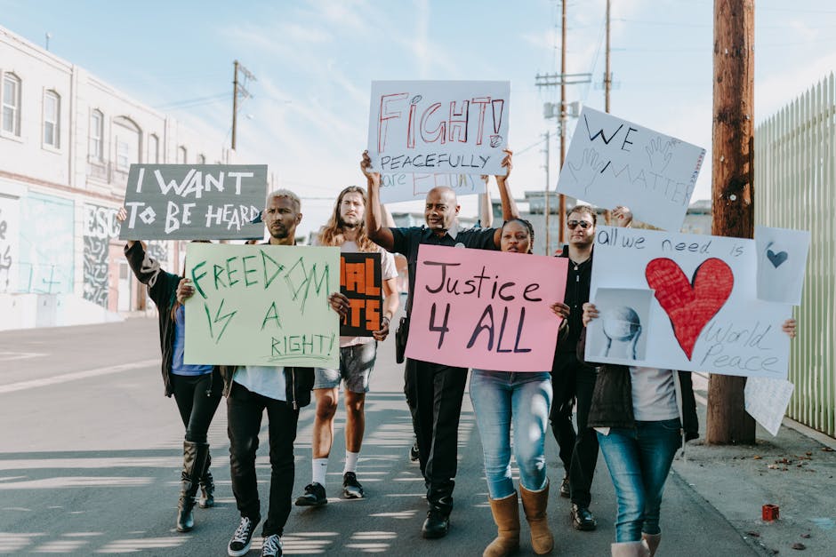 Group of activists hold signs advocating for justice and equality during a street protest.