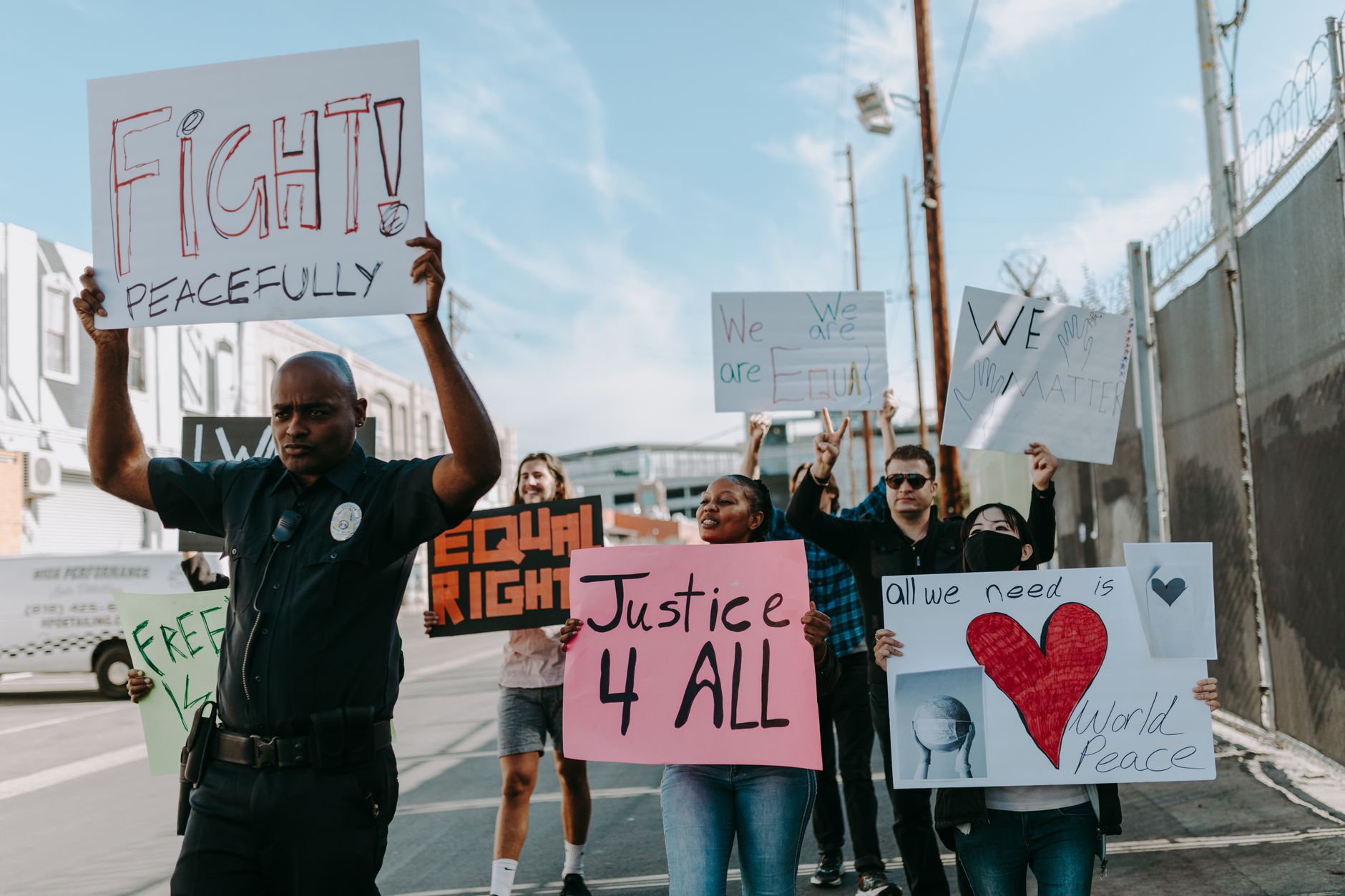 A diverse group of people peacefully protesting on a street, holding signs advocating for equality and justice.