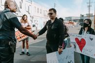 Man in Black Leather Jacket Holding White Paper