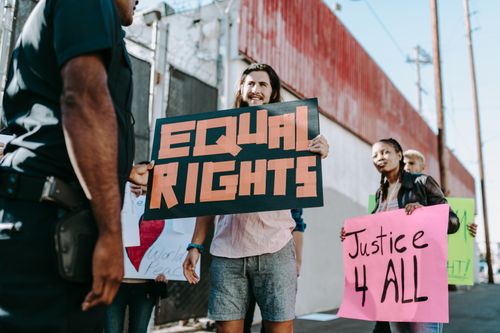 Free A diverse group of people holding protest signs advocating for equality and justice outdoors. Stock Photo