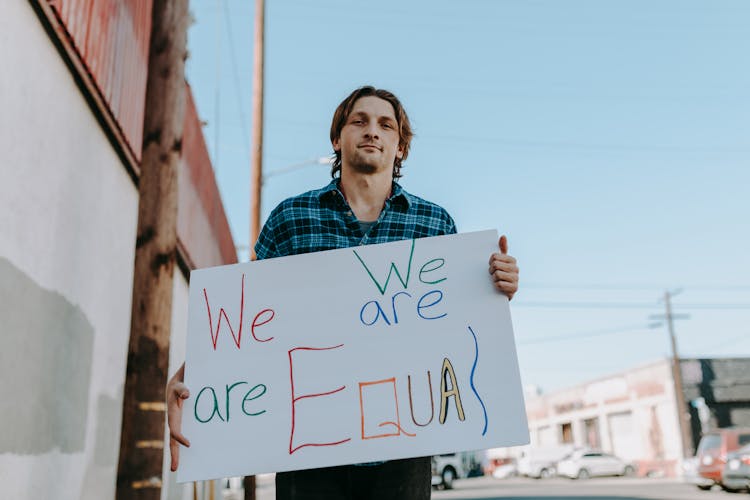 A Man Holding A Board With Message