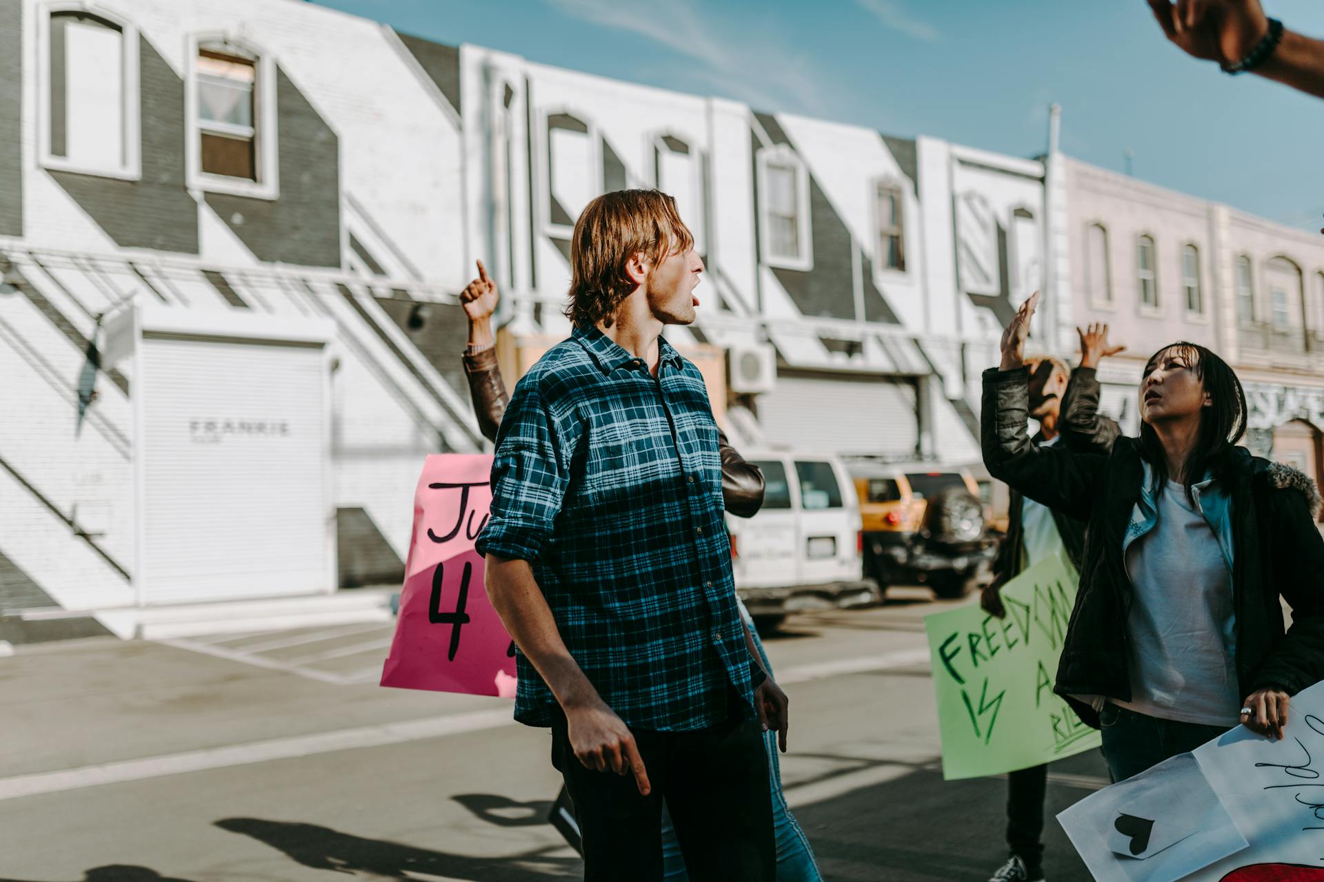 Group of People Holding Banners while Rallying on the Street