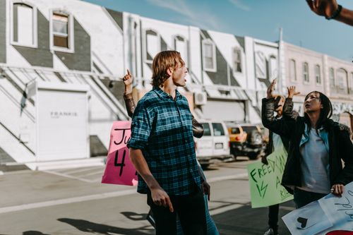 Free A group of protesters holding vibrant signs during a peaceful street rally. Stock Photo