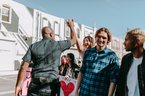 Free A joyful moment during a protest as a police officer and a protester share a high five. Stock Photo