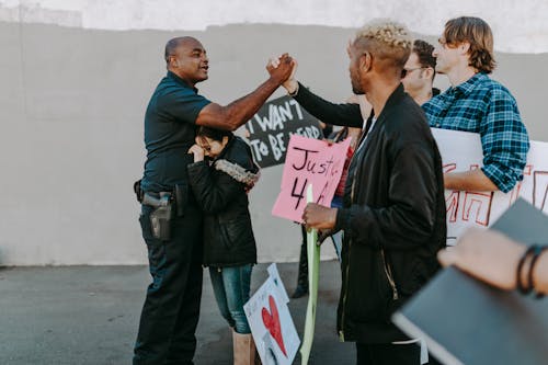 Free A Policeman Doing Handshake with Protesters Stock Photo