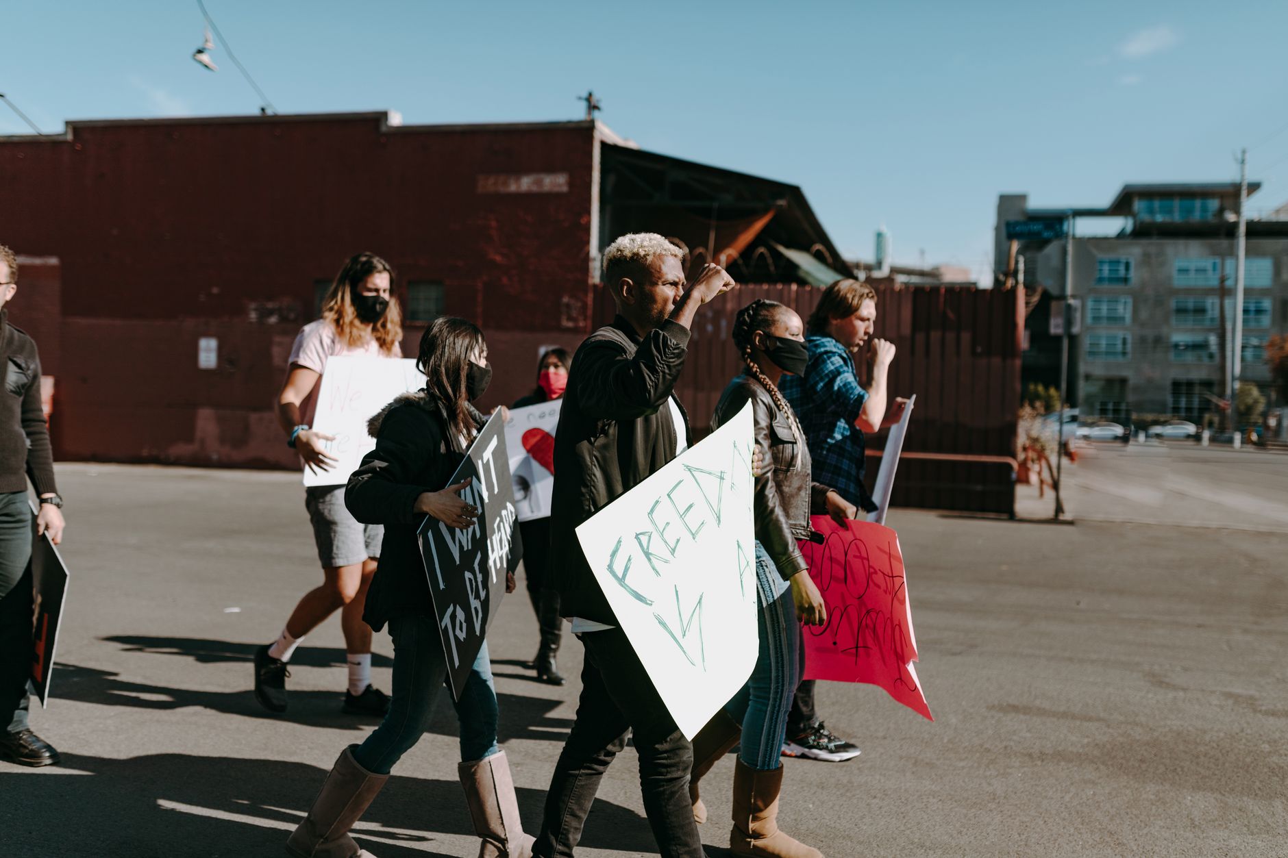 A diverse group of individuals peacefully rallying for freedom in an outdoor urban setting.