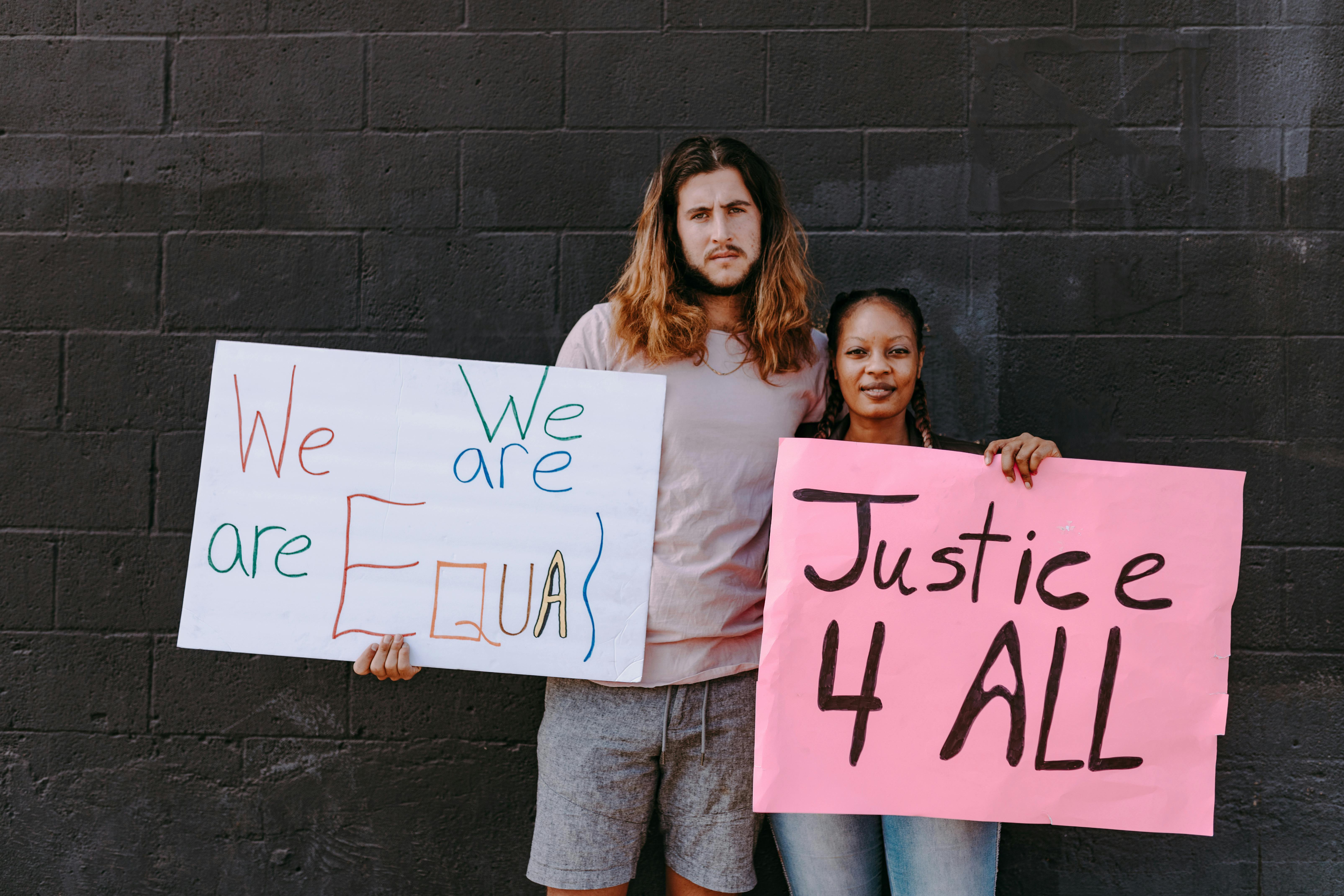 a man and woman holding protest banners