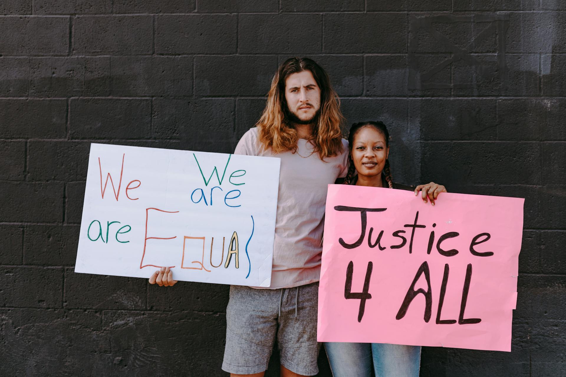 A Man and Woman Holding Protest Banners