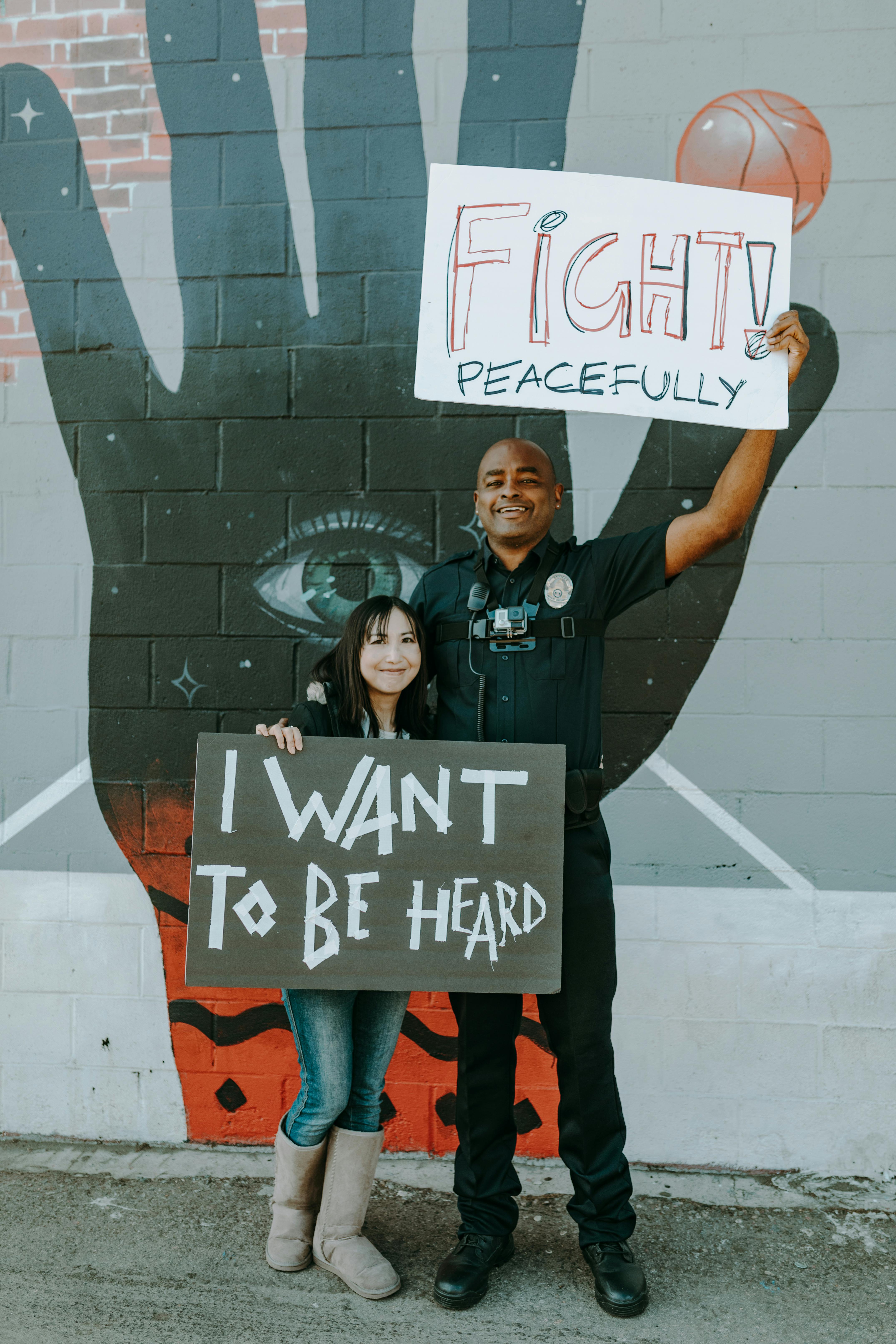 a policeman and woman holding protest banners