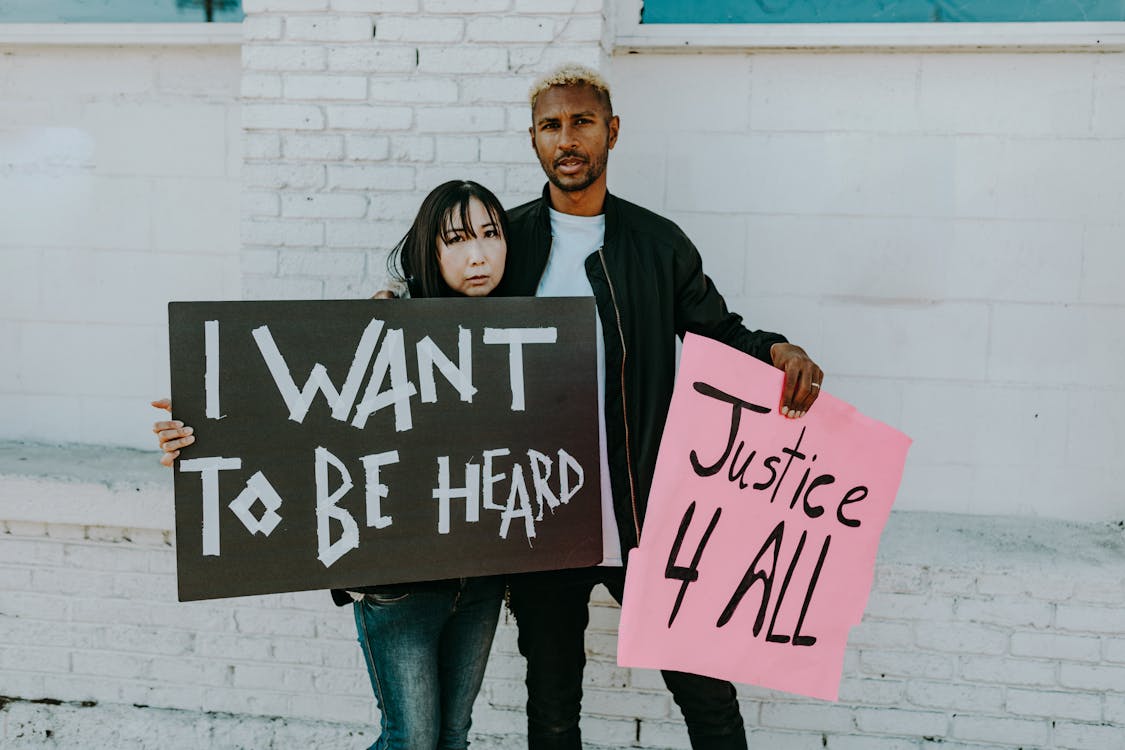 Free A Man and Woman Holding Protest Banners Stock Photo