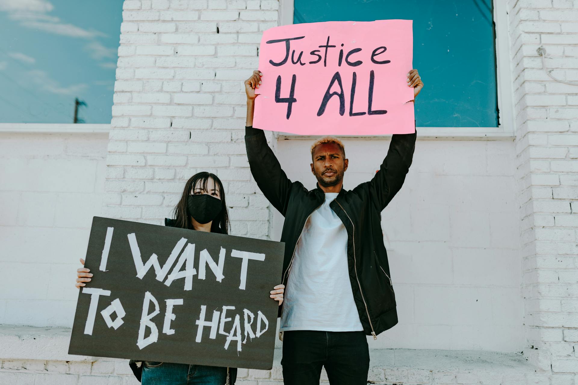 A Man and Woman Holding Protest Banners