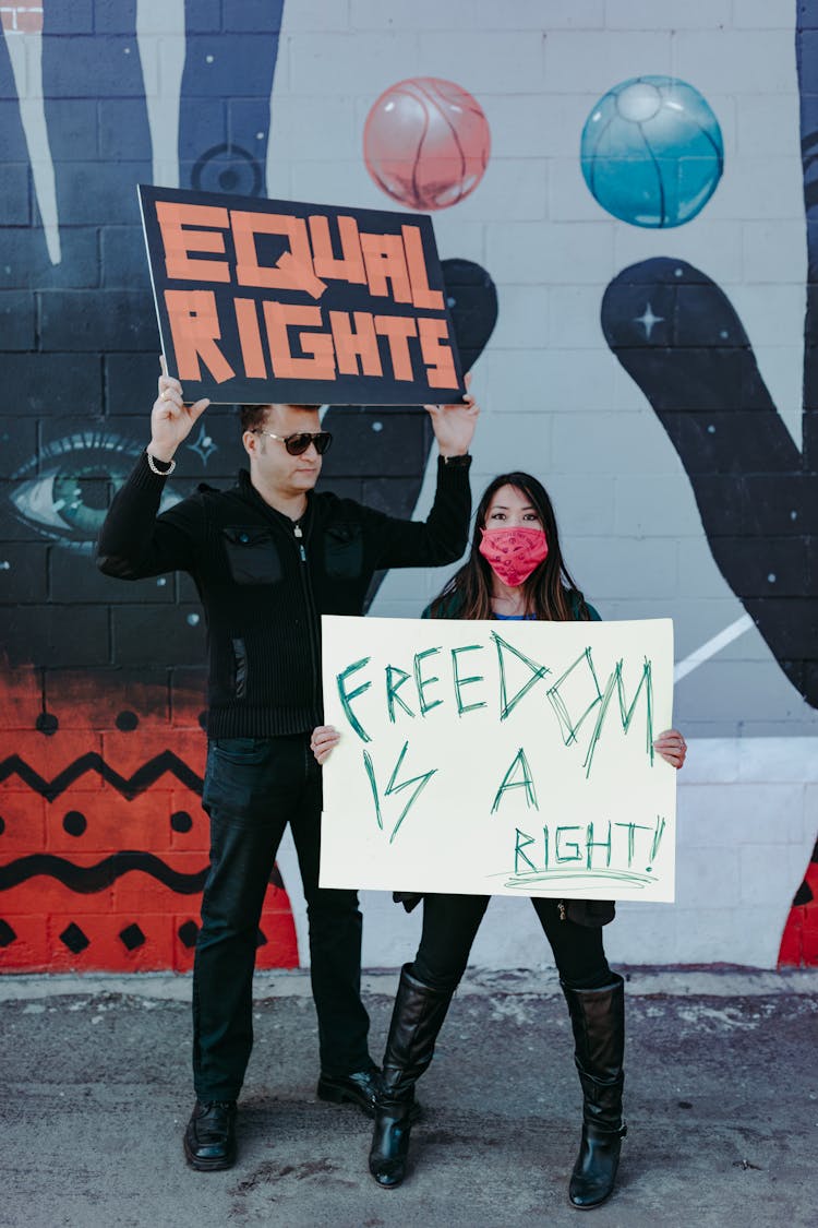 A Man And Woman Holding Protest Banners