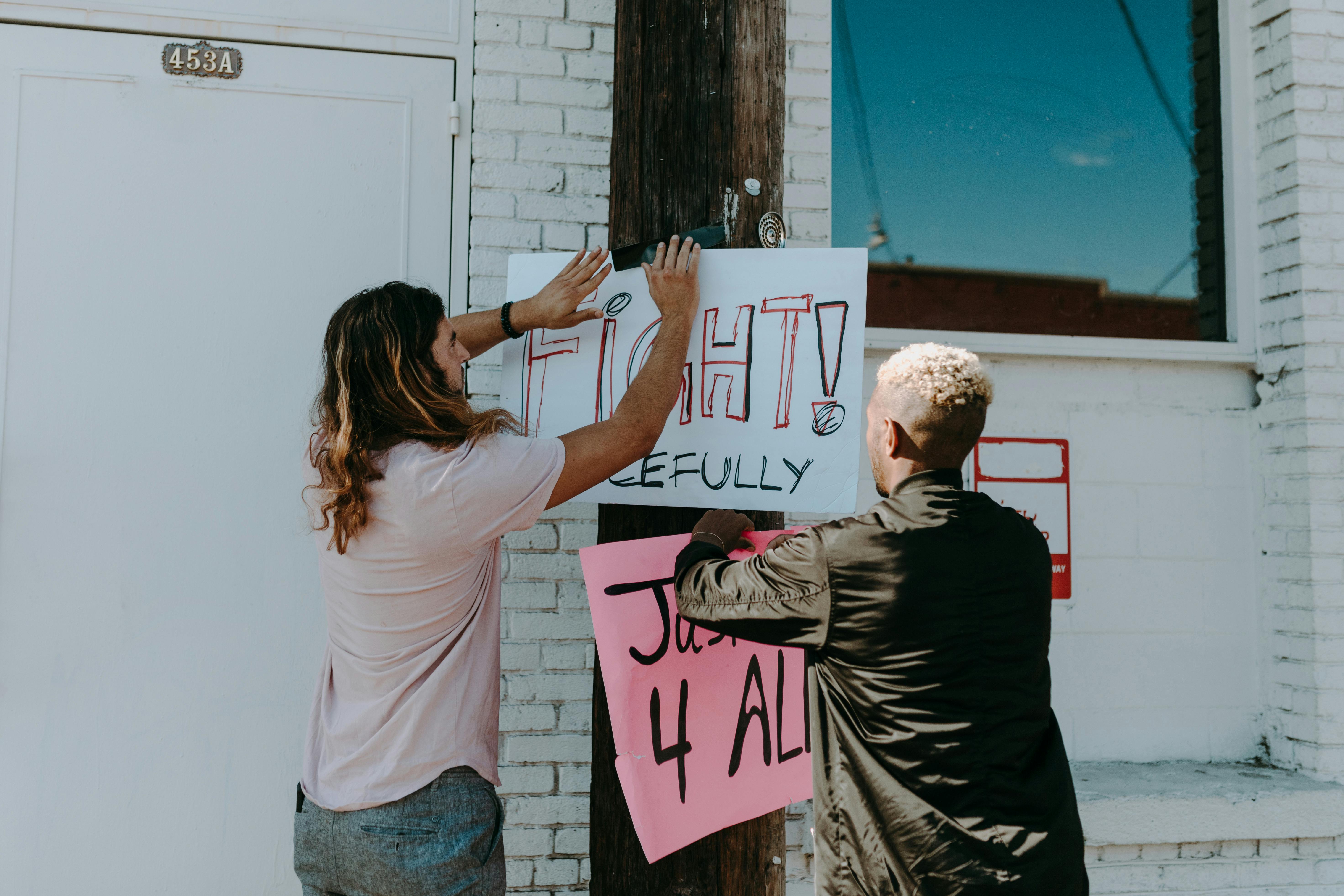 man and woman standing and holding white printer paper