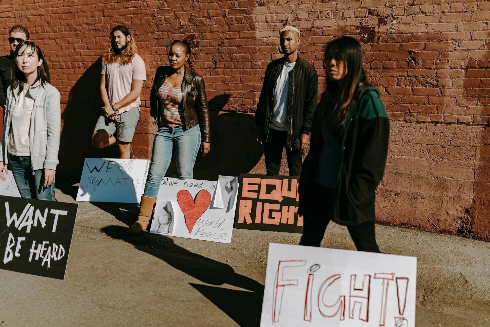 A diverse group of people holding signs advocating for equality and rights during an outdoor protest.