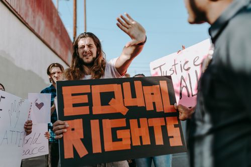 Free Activists holding 'Equal Rights' and other placards during a peaceful protest outdoors. Stock Photo