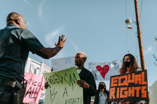 Free A group of protesters holding signs for freedom and equal rights during a daytime demonstration. Stock Photo