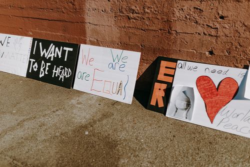Free Outdoor protest signs advocating equality and peace placed against a wall. Stock Photo