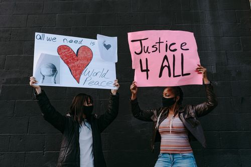 Free Women holding protest signs advocating for justice and peace, displaying unity and activism. Stock Photo