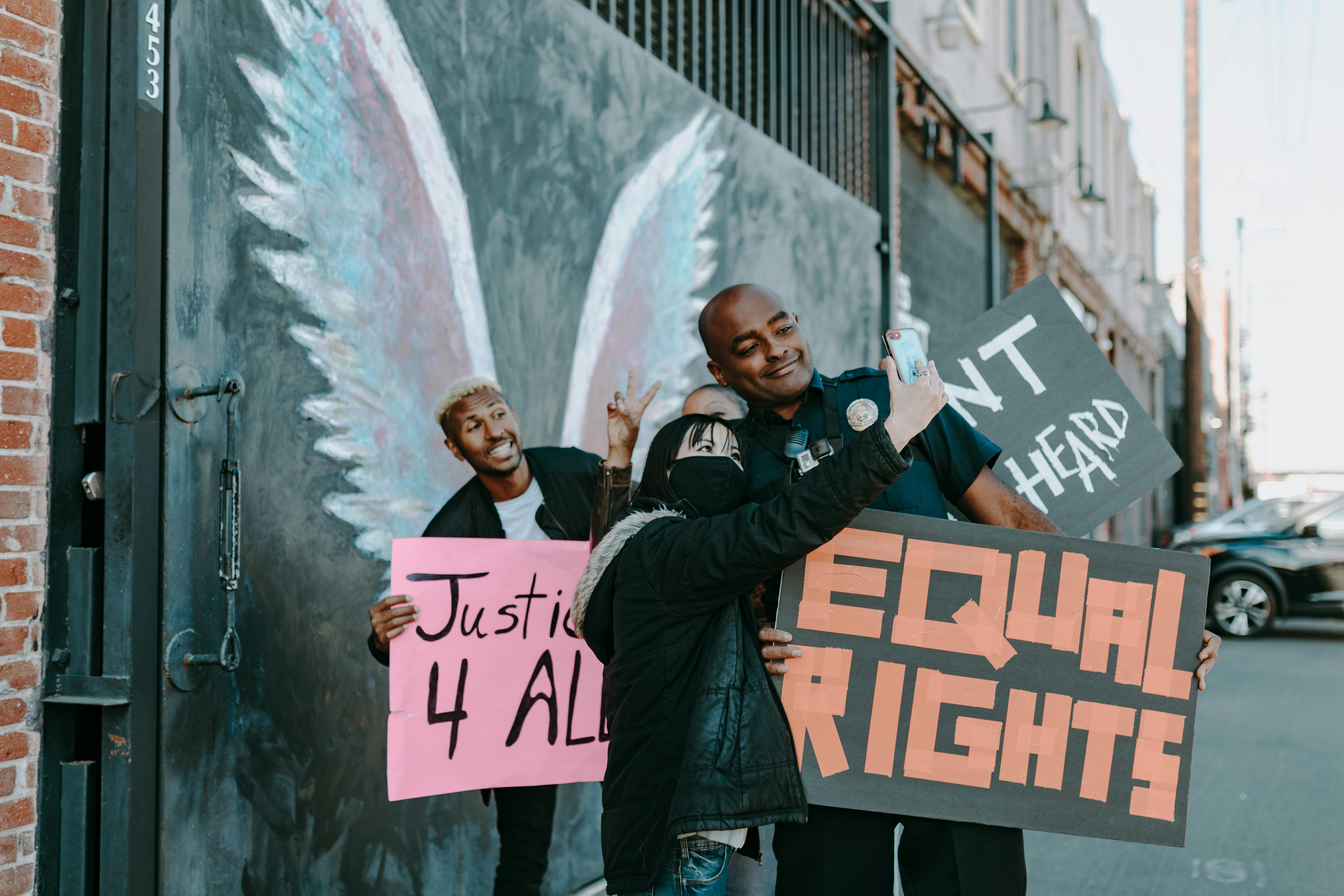 man in black jacket standing beside wall with graffiti