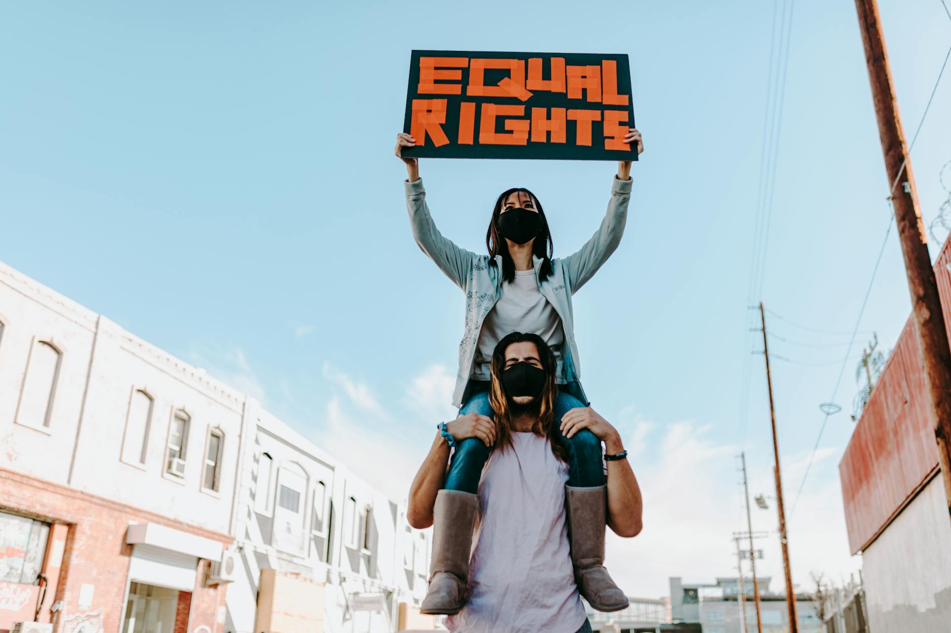 Two people at a protest holding an 'Equal Rights' sign, advocating for social justice.