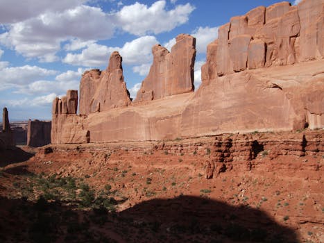 Stunning red rock formations under a bright blue sky in Arches National Park, Utah.