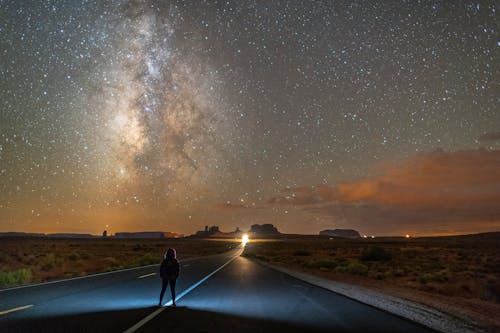 Person Standing Alone in Middle of Road at Night