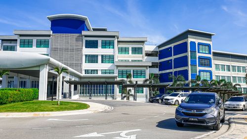 Free Modern building with blue accents and parked cars in Johor, Malaysia, under a clear sky. Stock Photo