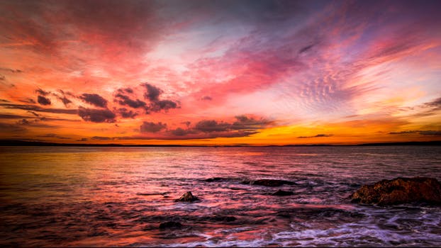 A breathtaking sunset over a tranquil ocean, with vibrant colors and serene atmosphere.