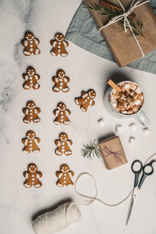 Gingerbread Cookies Laying with a Cup of Marshmallow Drink