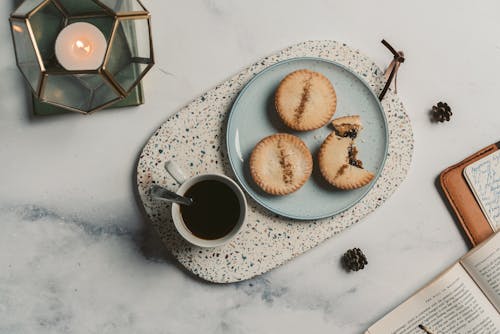 Free Cookies and a Cup of Coffee Beside A Candle Light Stock Photo