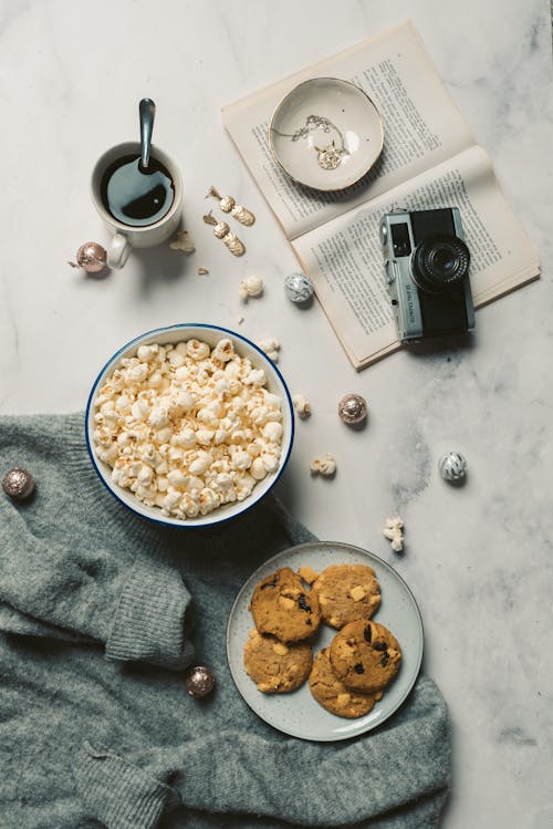 Cookies and Popcorns with Cup Coffee on a Table