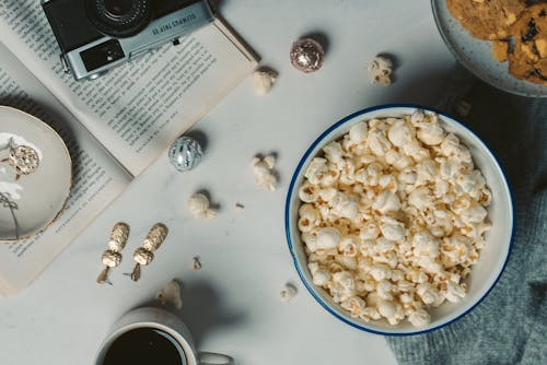 Bowl of Popcorn and Snacks Lying on a Table