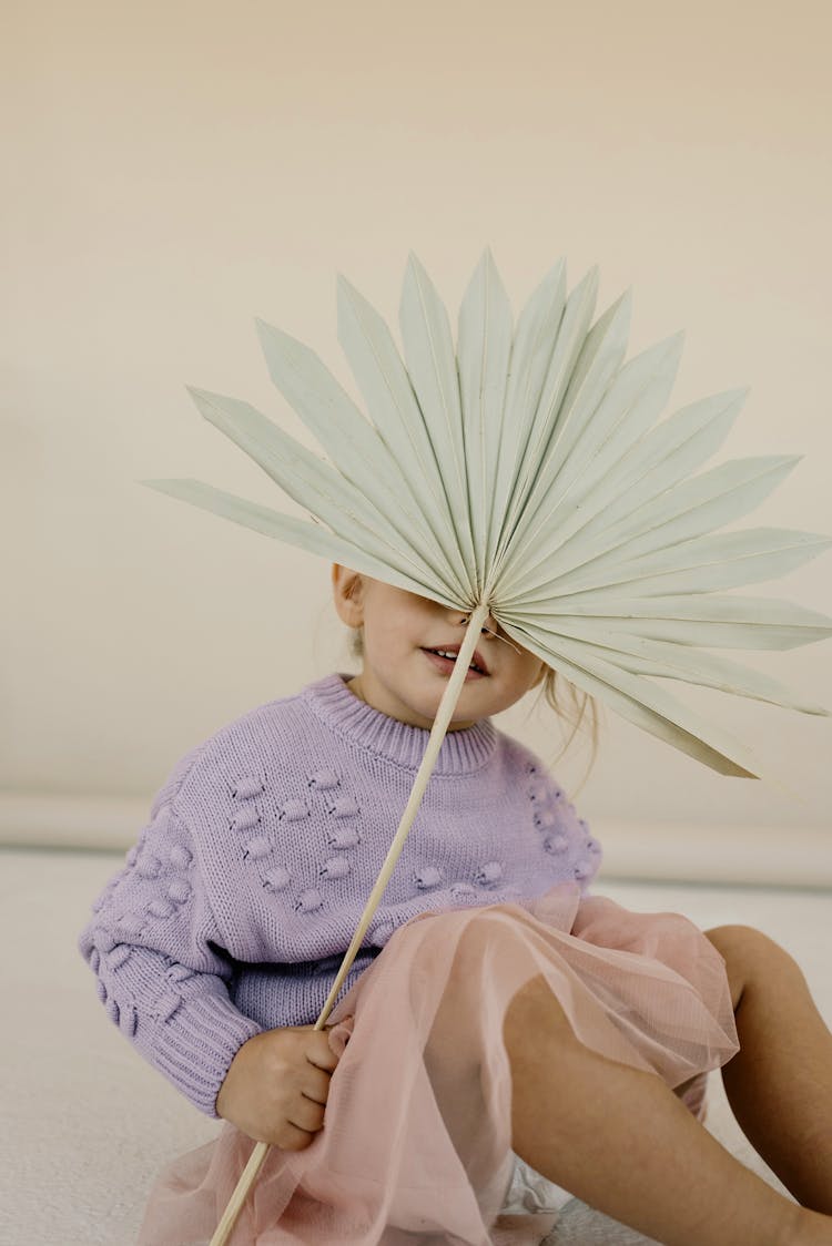 Child Holding An Origami Fan