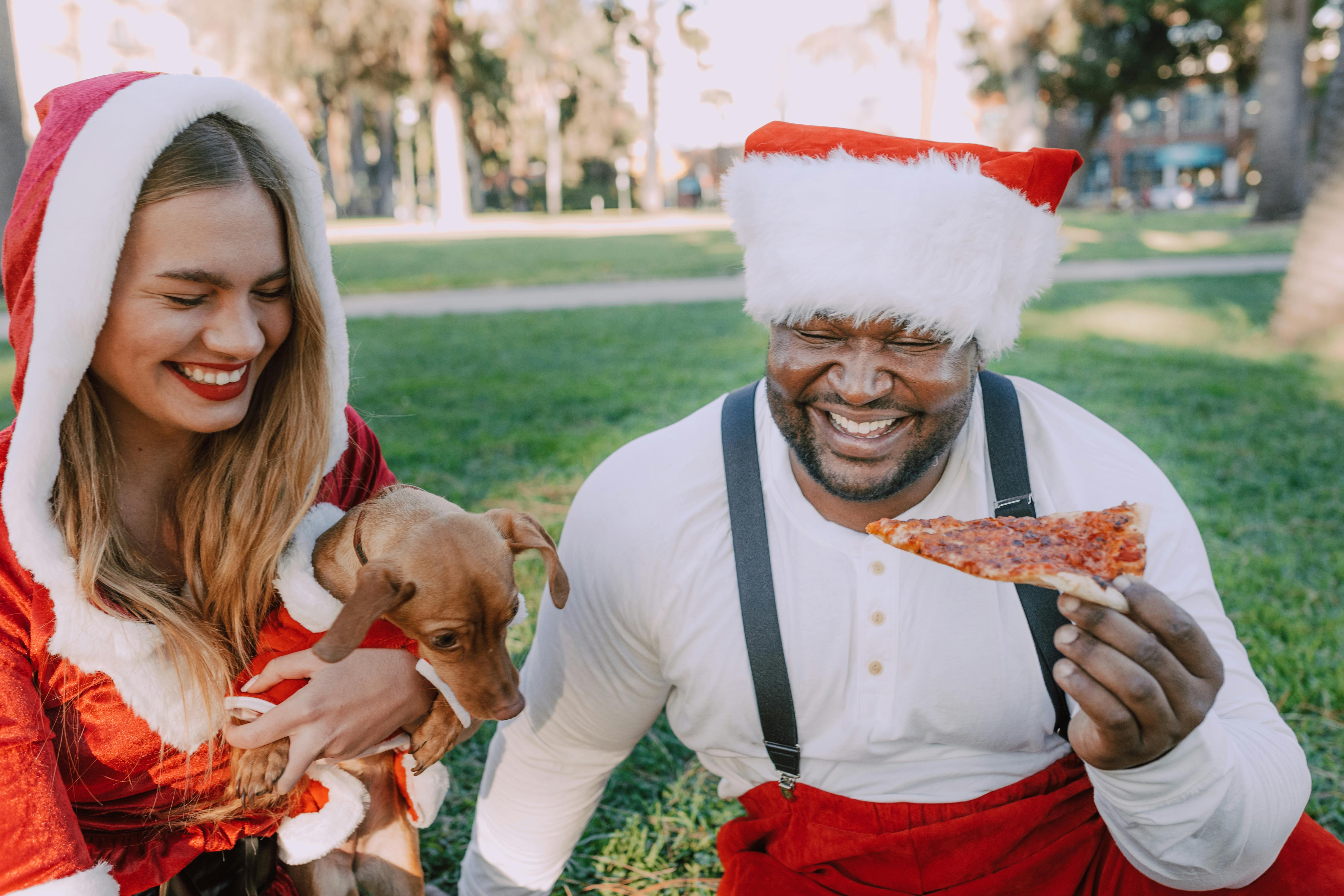 man in santa costume hugging woman in white tank top