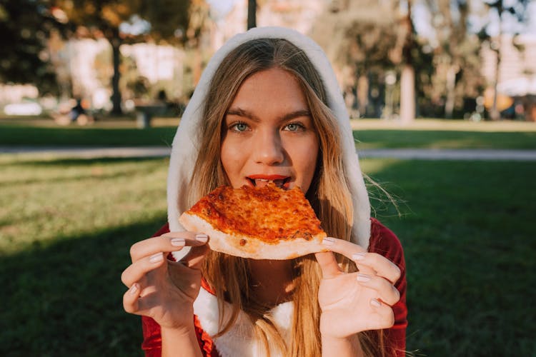 Portrait Of A Woman Eating A Pizza Slice