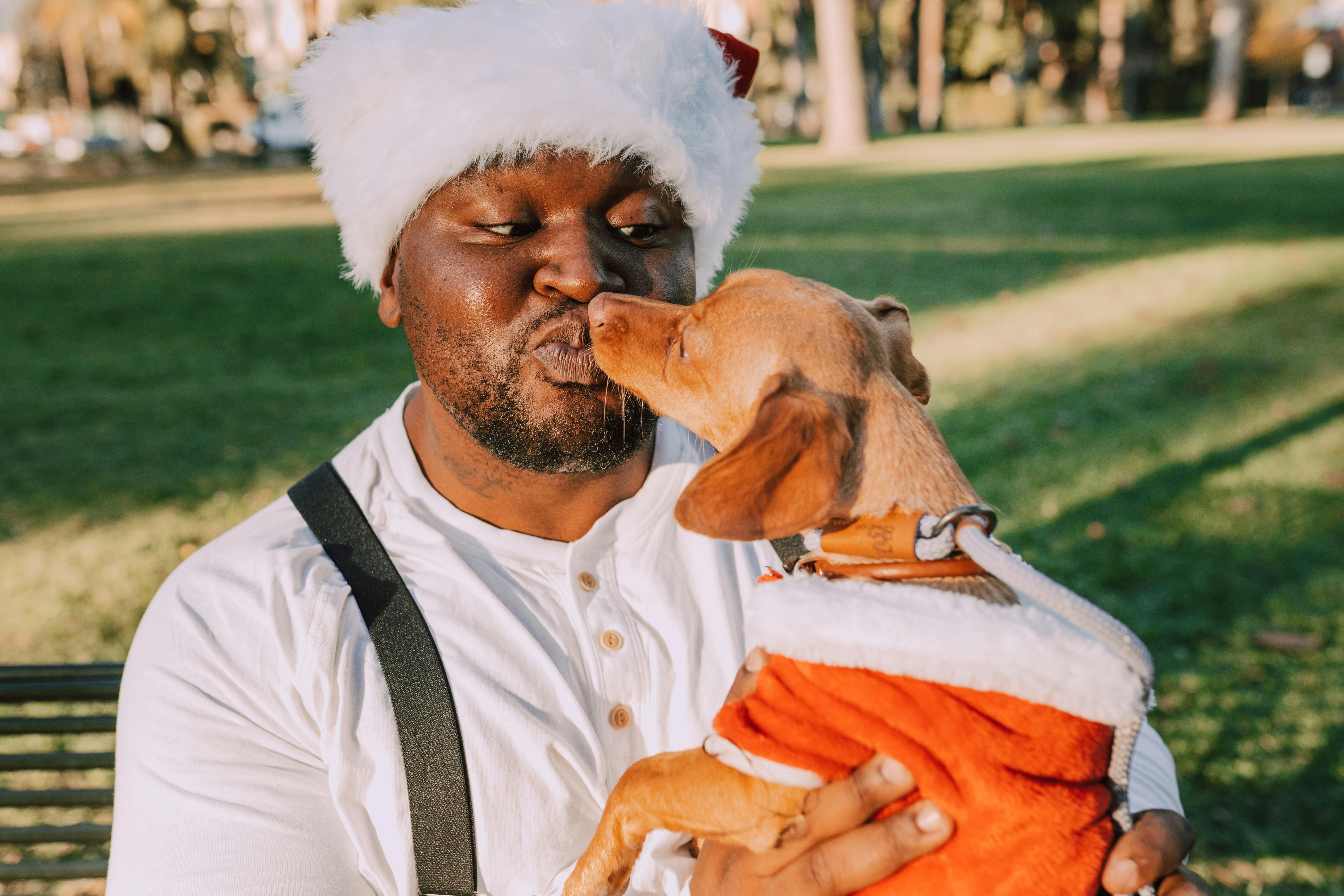 man in white crew neck shirt carrying brown dog