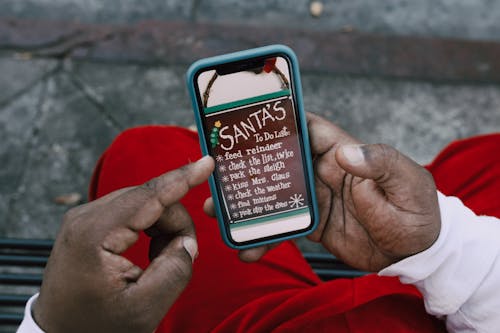 Close-Up Shot of a Person Looking at a Santa's To Do List