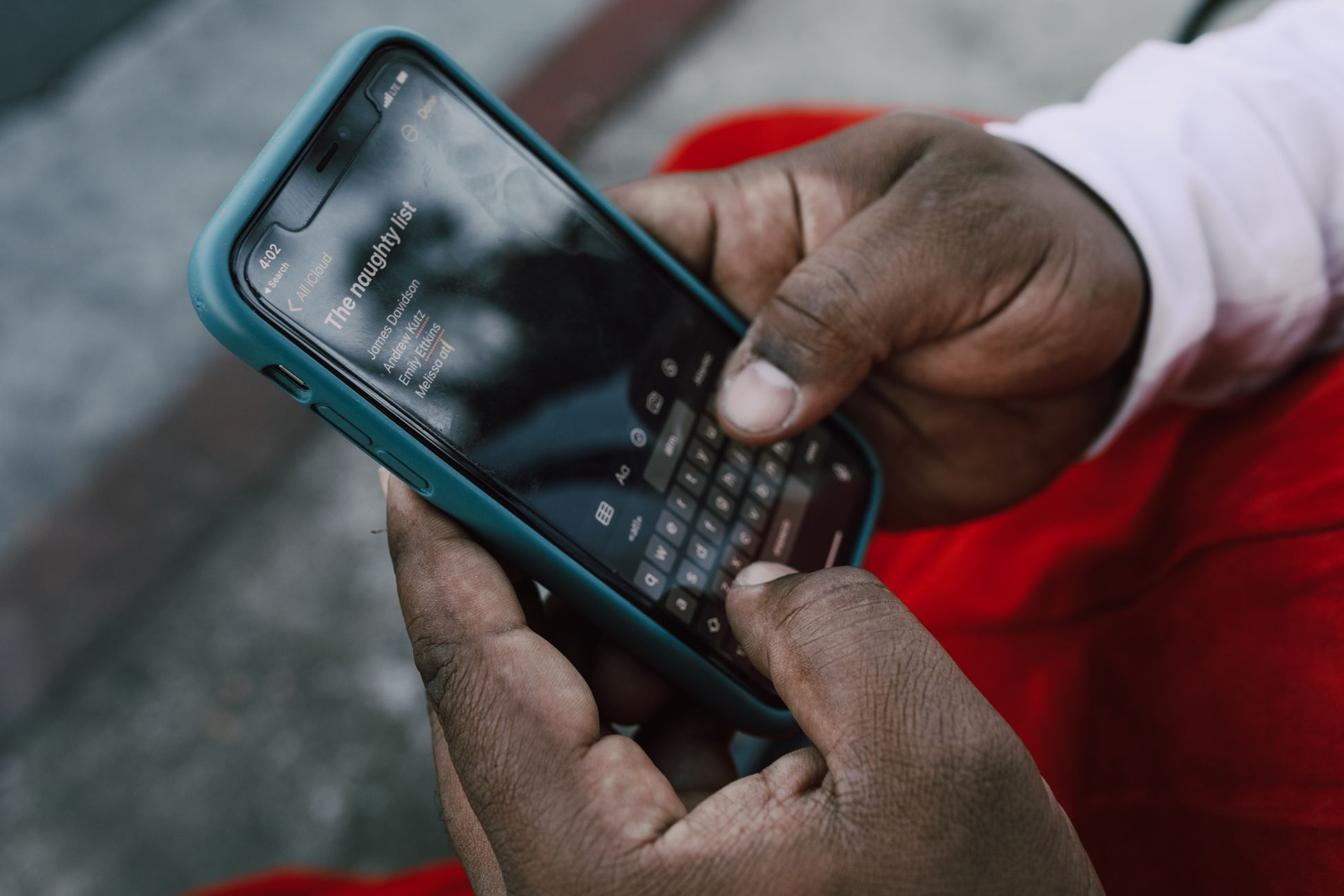 A person typing on a smartphone displaying a list titled 'The naughty list'.