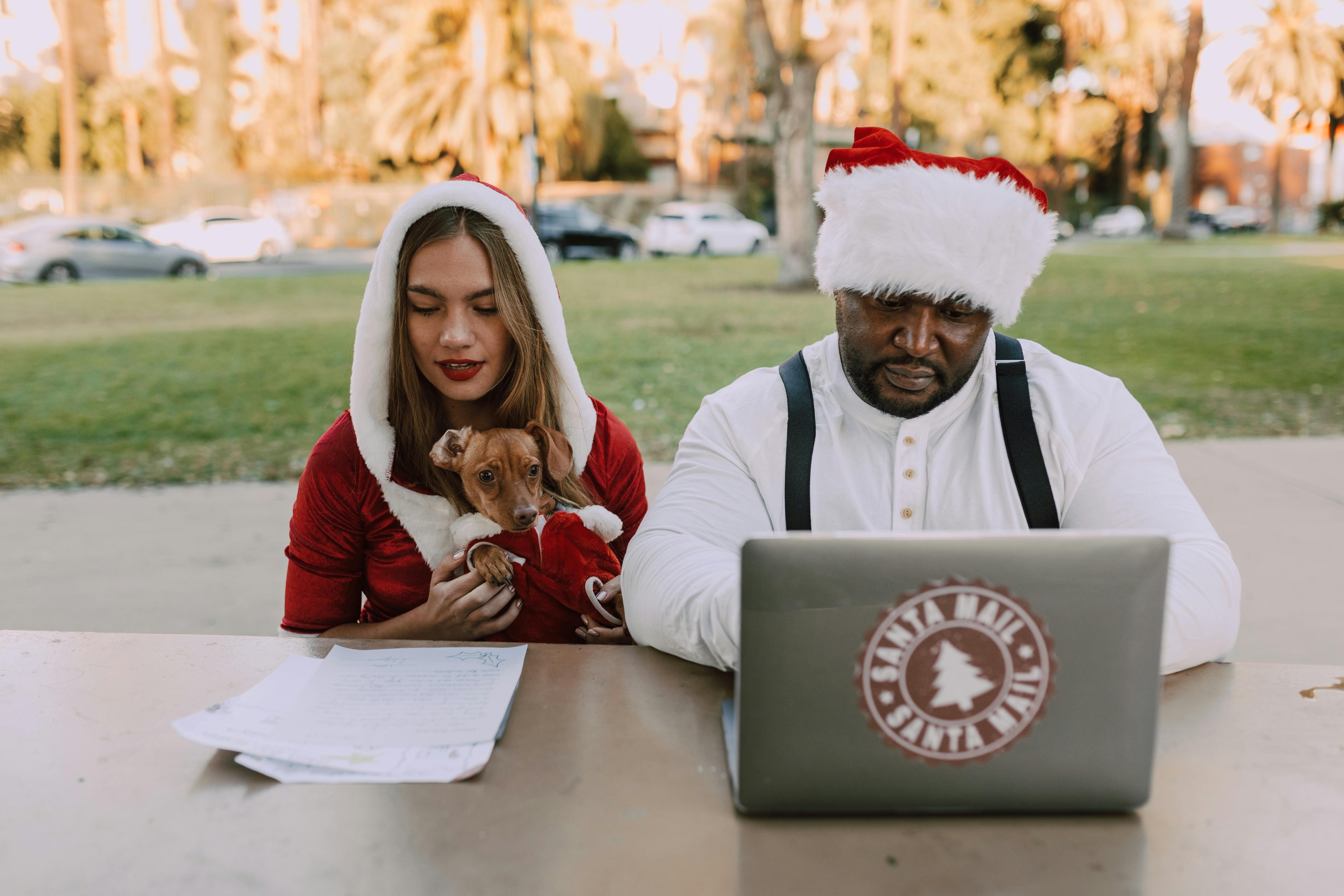 man in santa claus costume sitting beside woman in santa costume