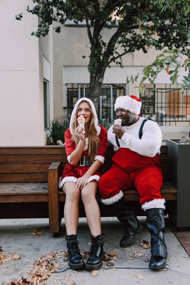 A Man And A Woman Sitting On Brown Wooden Bench