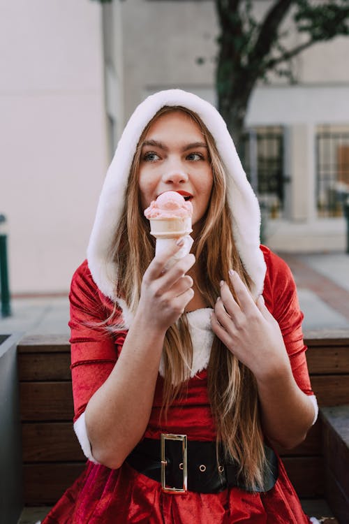 A Woman Wearing Santa Costume Eating Ice Cream