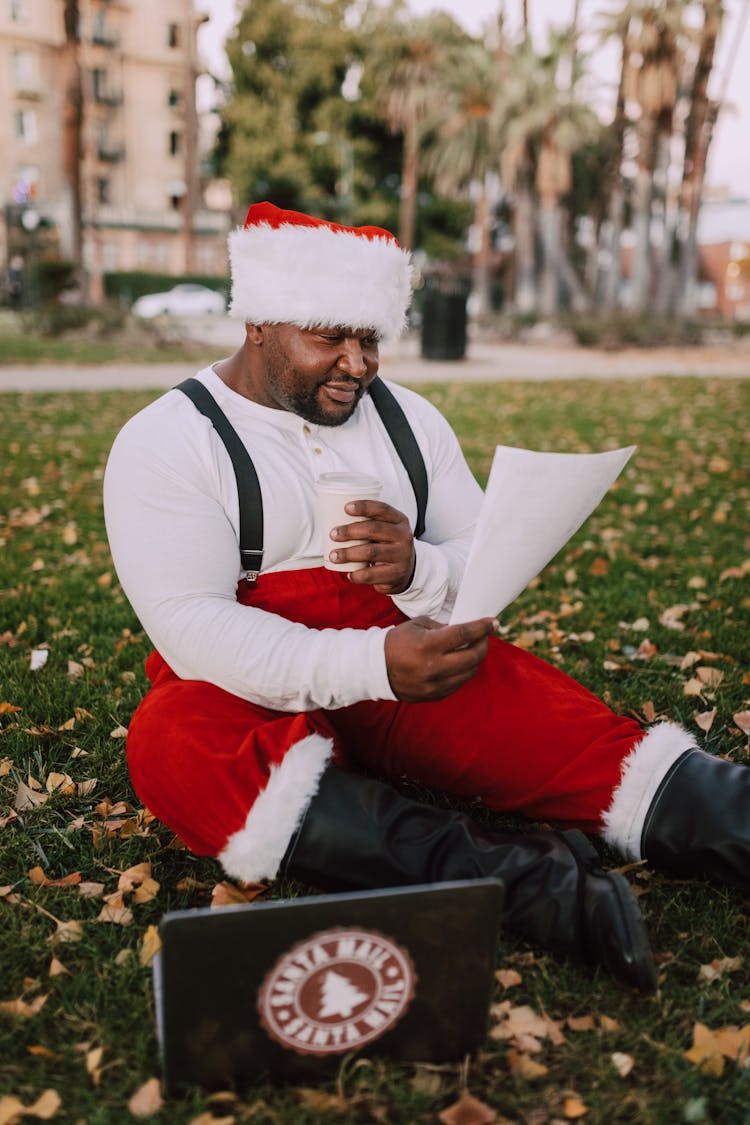 Man In Santa Outfit Reading A Letter