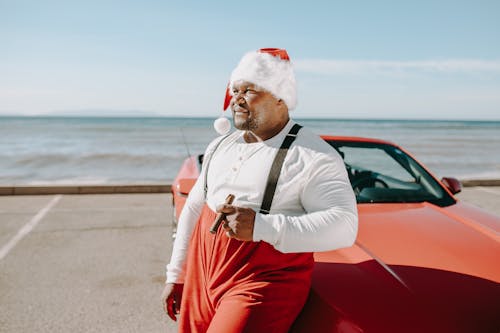 Free A Man in White Dress with Long Sleeves Standing Beside the Red Car Stock Photo