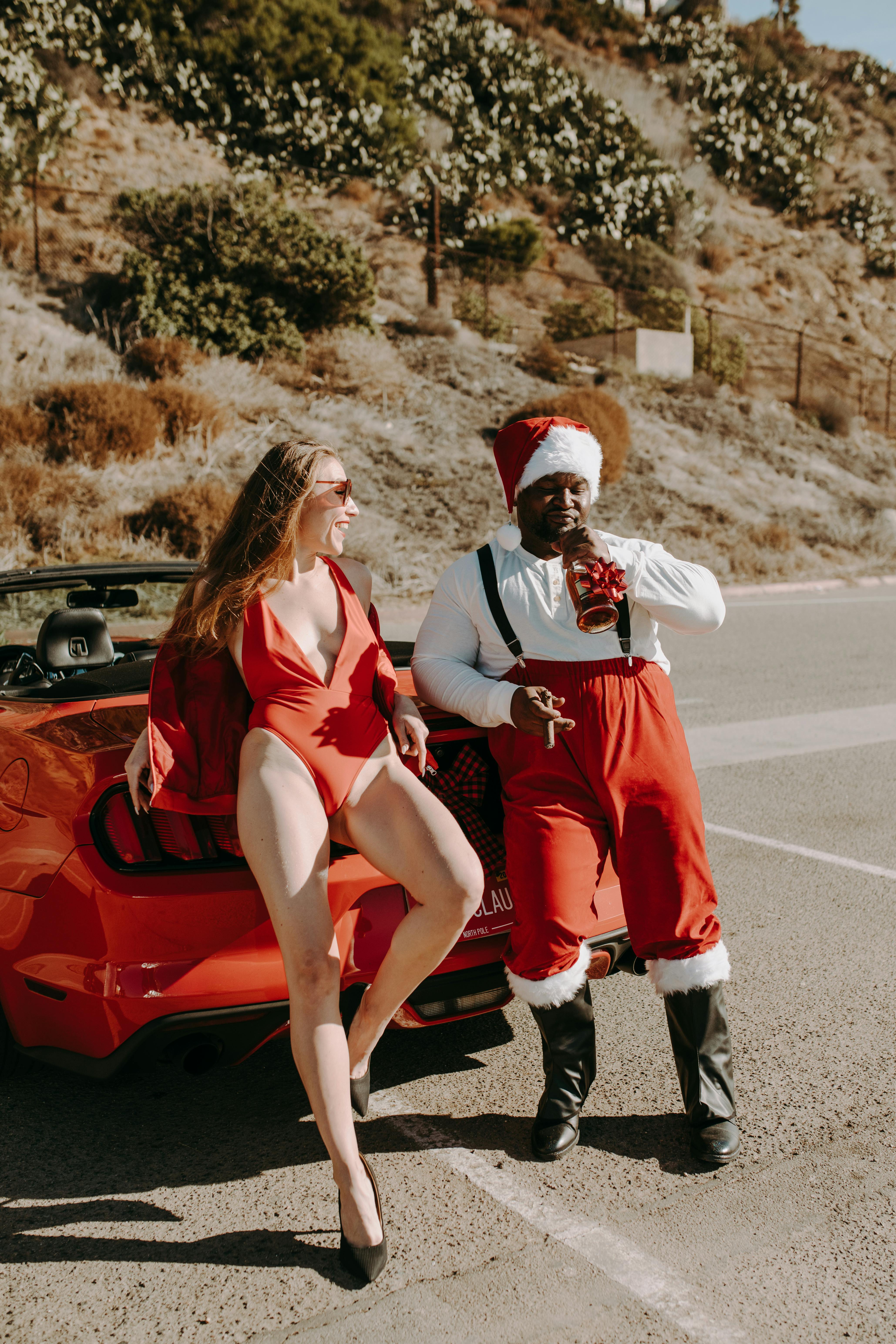 woman in red and white long sleeve dress sitting on red car