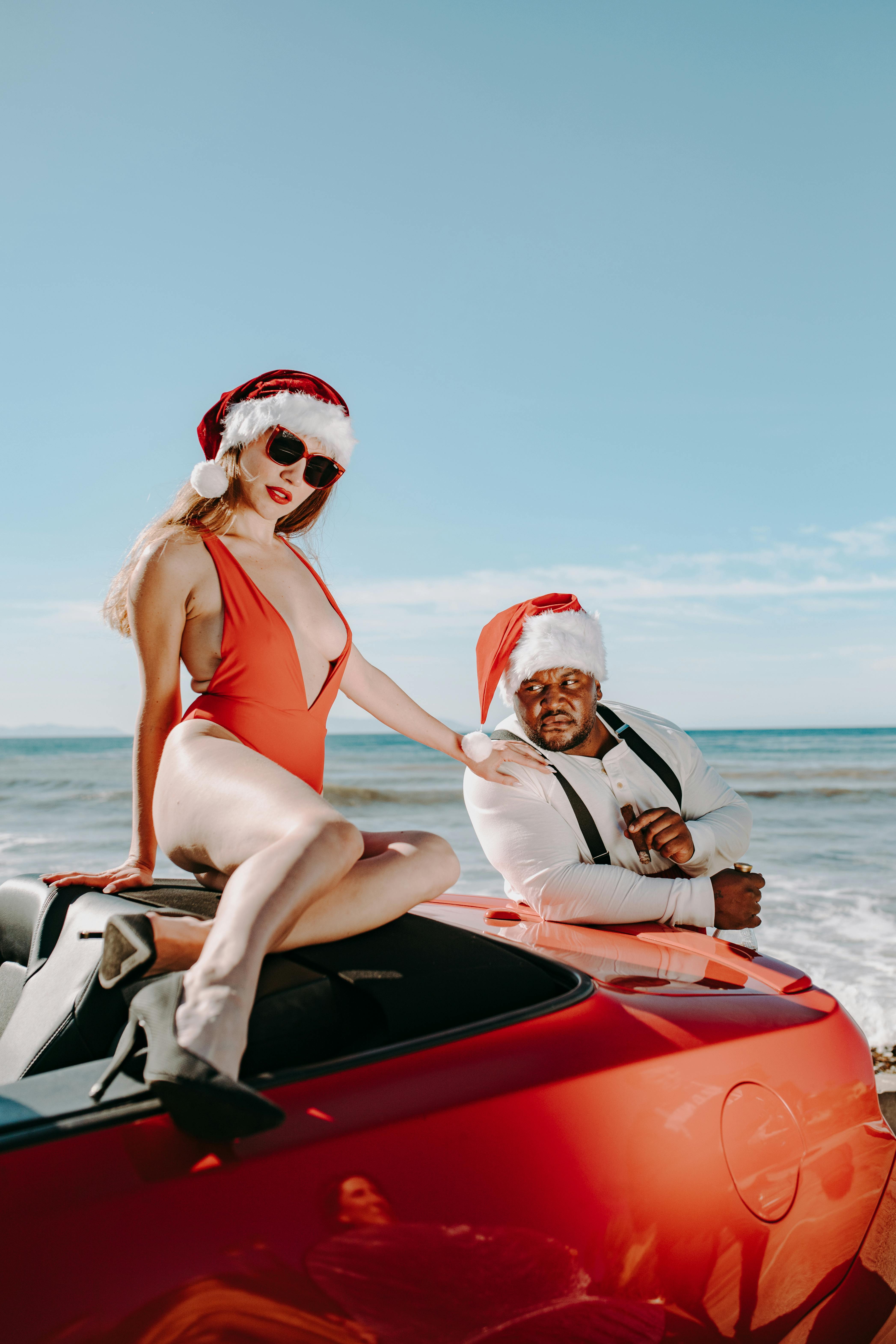 man and a woman wearing santa hats